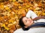 Young Woman Lying on Autumn Leaves