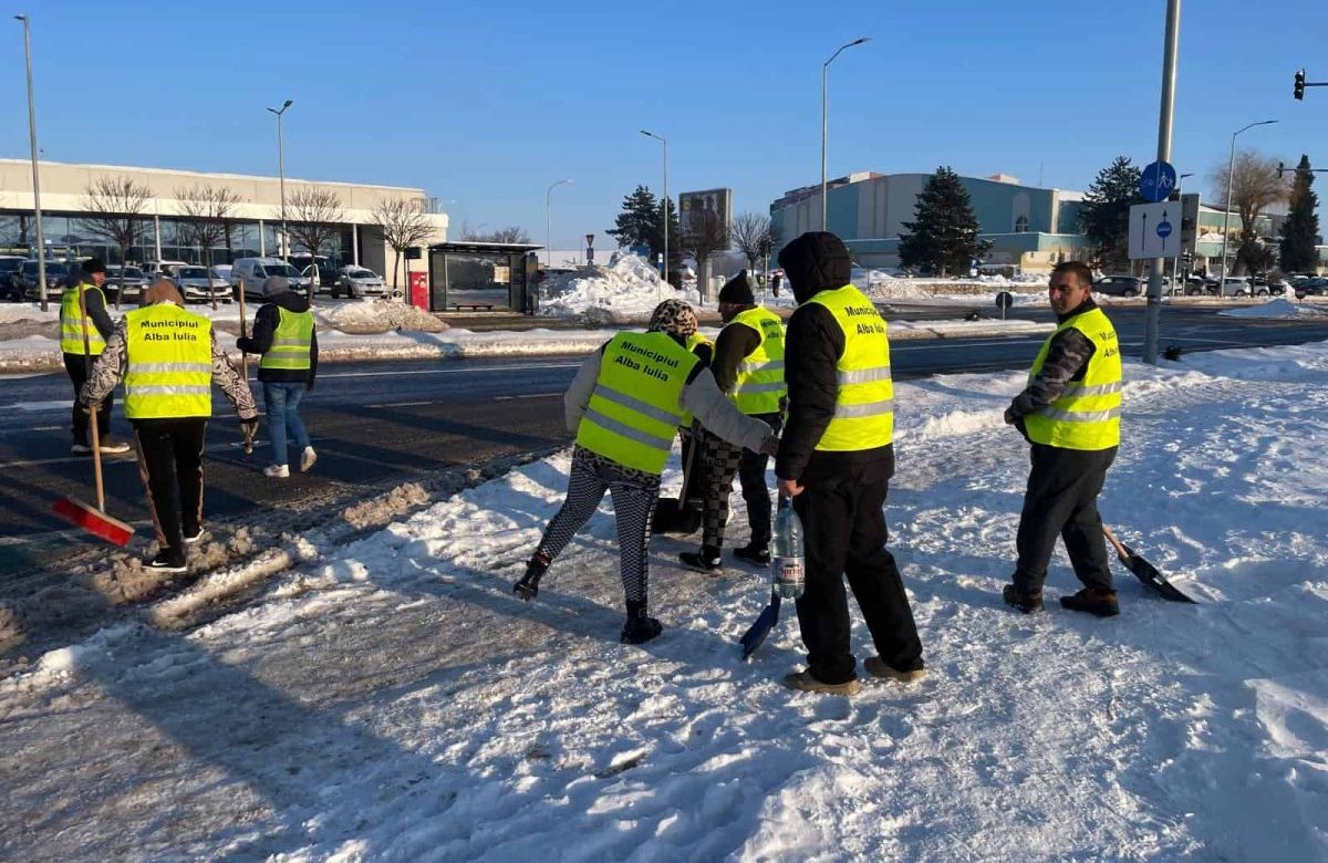 FOTO Beneficiarii de ajutor social participă la deszăpezire în Alba Iulia. Stațiile de autobuz și trecerile de pietoni, prioritare