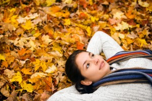 Young Woman Lying on Autumn Leaves