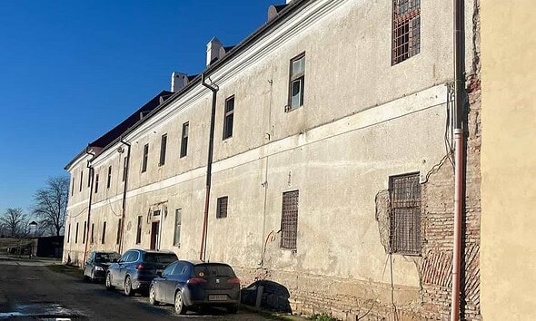 Clădire veche cu ferestre metalice și pereți deteriorați, situată în Alba Iulia, reprezentând activi.