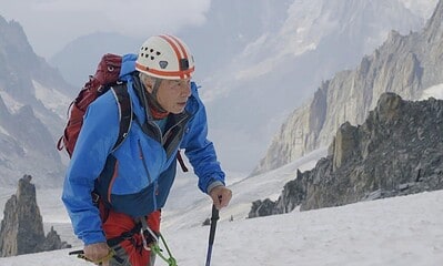 Alpinist în vârstă de 86 de ani urcând pe munți în Alpi.