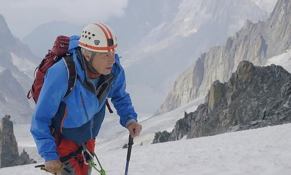 Alpinist în vârstă de 86 de ani urcând pe munți în Alpi.