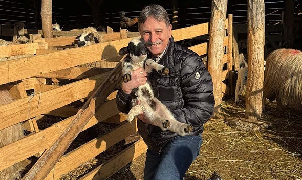 Ion Dumitrel cu un miel în ferma de ovine din Fărău.