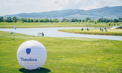 Teren de golf Theodora Golf Club în primăvară, cu jucători și peisaje verzi.