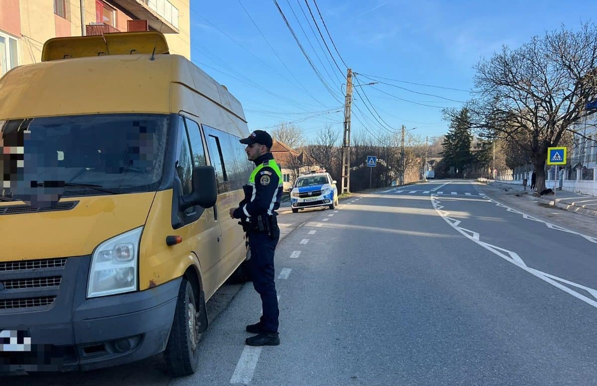 Polițist în acțiune verificând un vehicul pe stradă în Ocna Mureș.