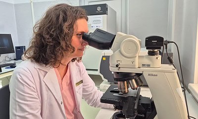 Cercetătoare folosind microscopul în laboratorul de microbiologie al spitalului.