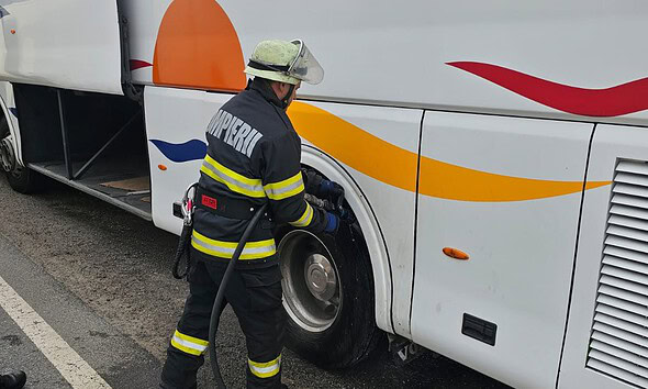 Pompier verificând cauciucul unui autobuz în timpul intervenției la Unirea.