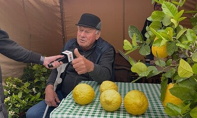 Bărbat explicând secretul lămâilor uriașe de Colțești la târg.