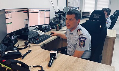 Dispecer ISU Alba monitorizând apeluri de urgență pe multiple ecrane.