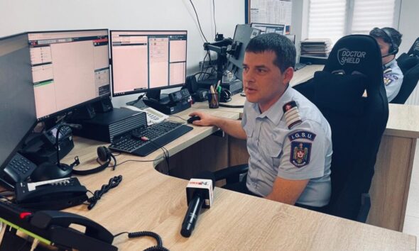 Dispecer ISU Alba monitorizând apeluri de urgență pe multiple ecrane.