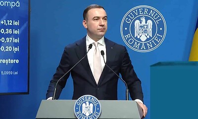 Președintele României susține o conferință de presă în fața unui logo guvernamental.