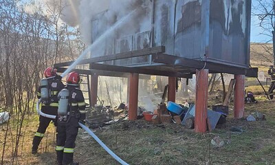 Pompieri stingând focul de la containerul modular din Săsciori.