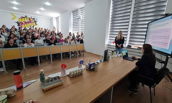 Copii și educatori participând la workshop interactiv organizat de grădiniță și universitate.