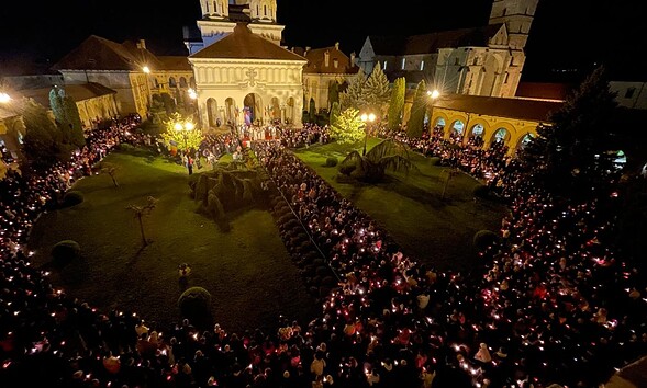 Procesiune de Paște cu lumina sfântă în curtea unei biserici din România.