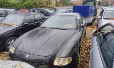 Mașină Audi neagră, pregătită pentru licitație, expusă în parcare cu alte vehicule.