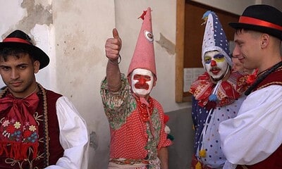Grup de oameni în costume tradiționale și măști de carnaval la ritualul Fărșang din Rimetea.