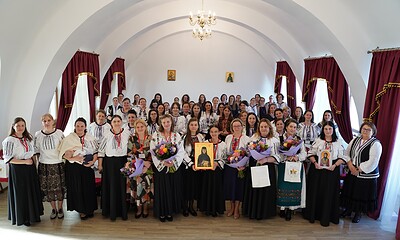 Oameni îmbrăcați în costume tradiționale românești la un eveniment cultural.