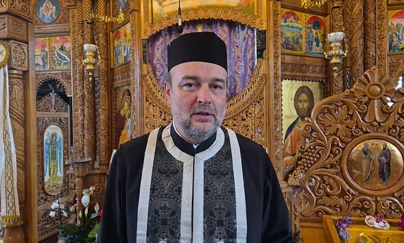 Imagine cu preot ortodox în interiorul bisericii, înconjurat de icoane și decoruri religioase elabor.