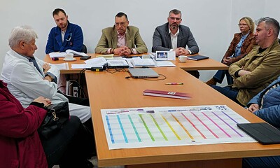 Imaginea arată o întâlnire de afaceri cu mai mulți participanți în sala de conferințe, discutând pla.