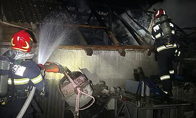 Pompieri din Aiud stingând focul într-o gospodărie afectată de incendiu. Intervenție rapidă cu două.
