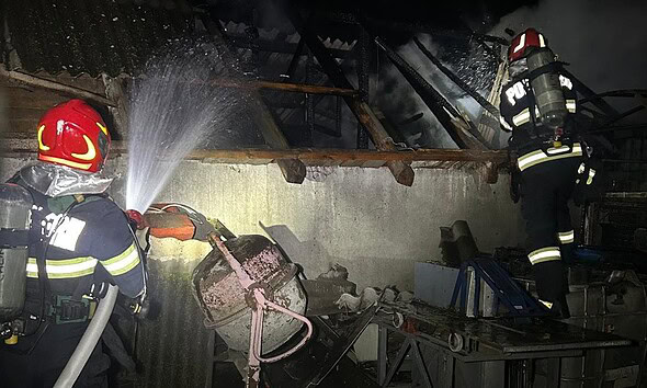 Pompieri din Aiud stingând focul într-o gospodărie afectată de incendiu. Intervenție rapidă cu două.